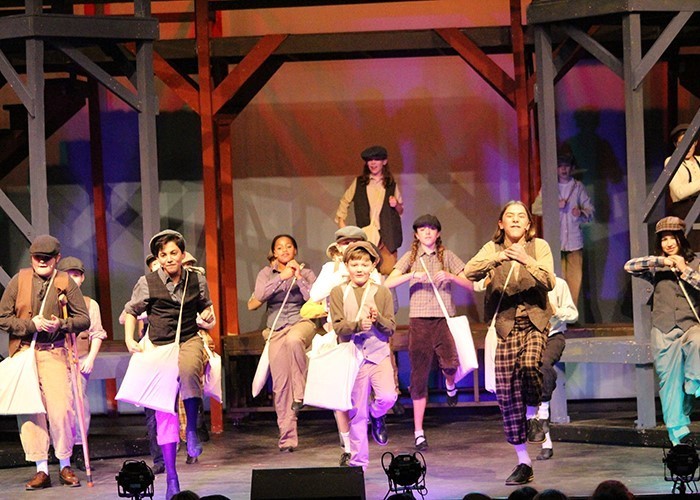 Image of a large group of middle school actors on stage in the midst of a musical dance scene