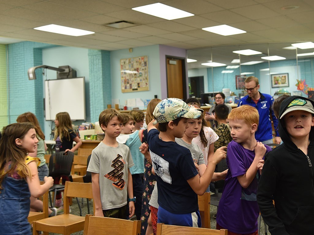 Image of about a dozen young school children working together in an activity