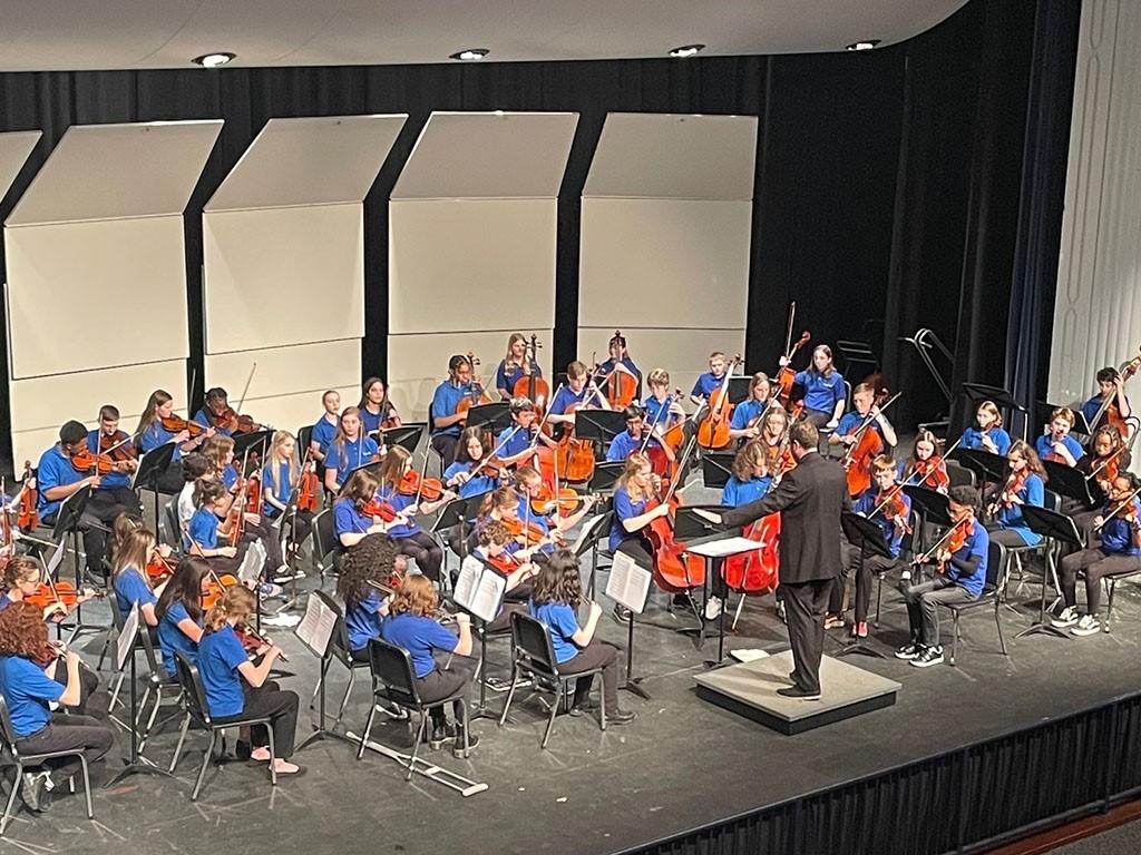 Image of a school orchestra performing on stage
